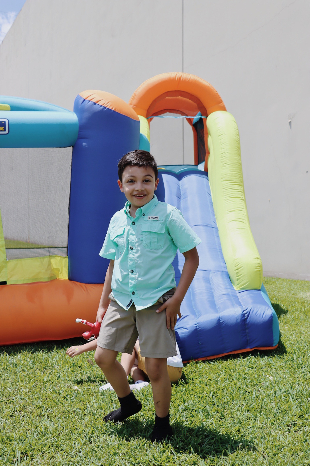 boy playing on blow up slide