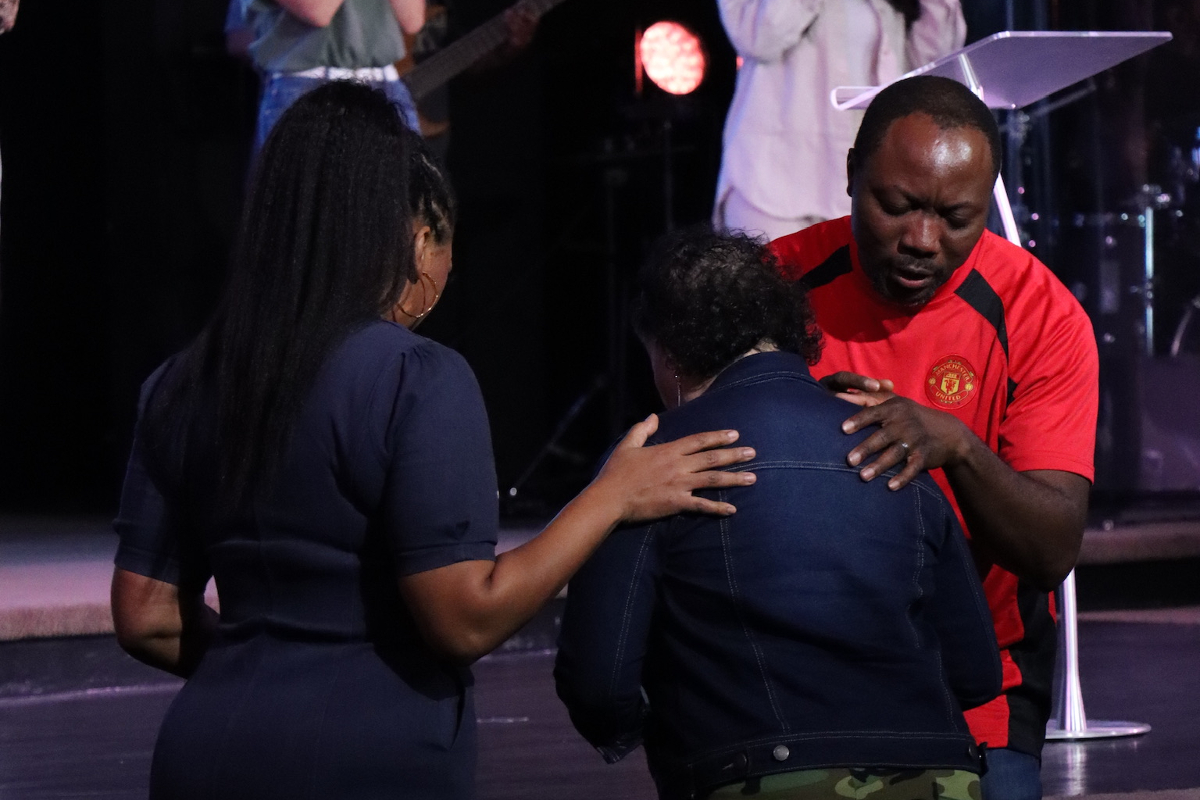 two people praying over another