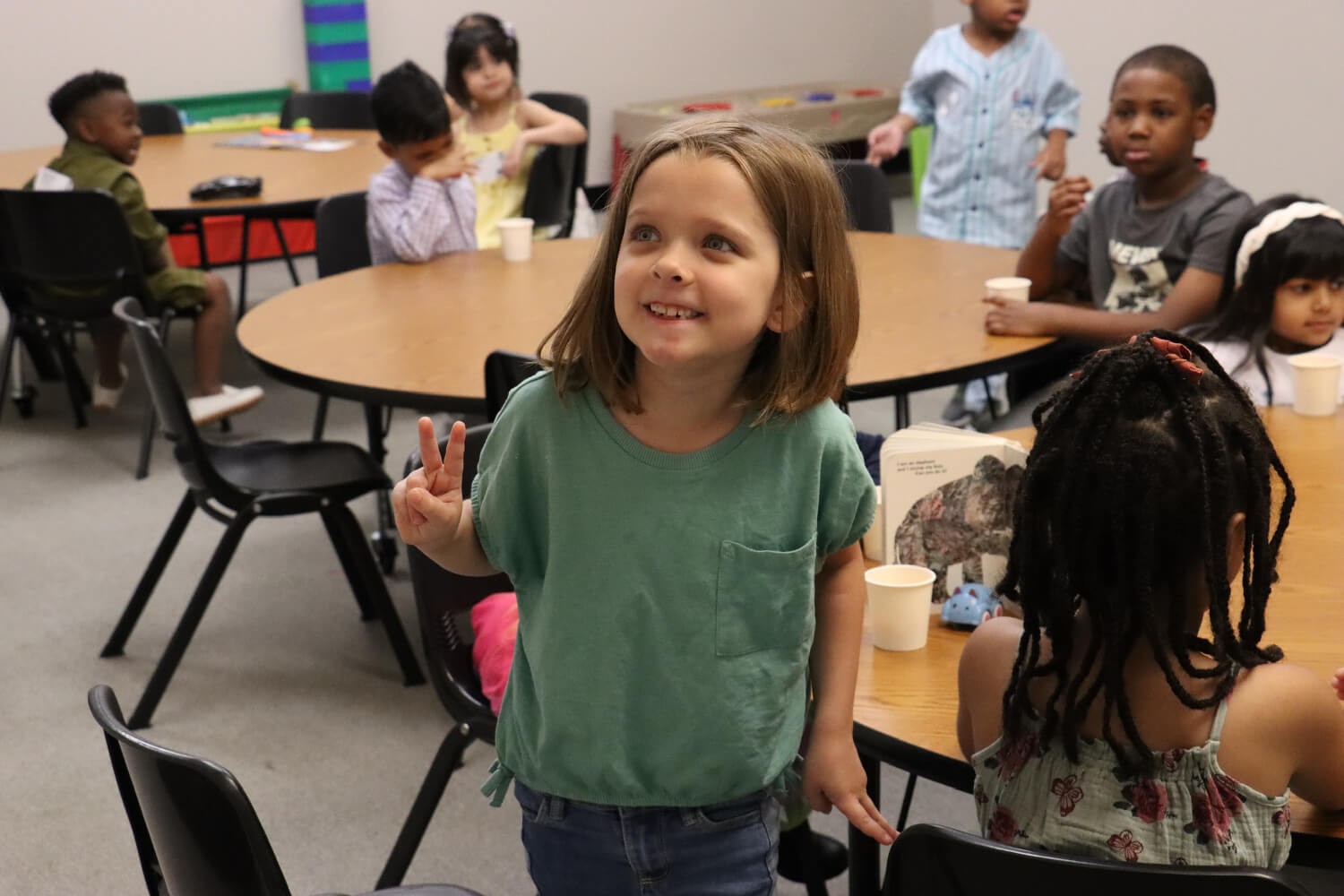 room of kids with one girl in front smiling