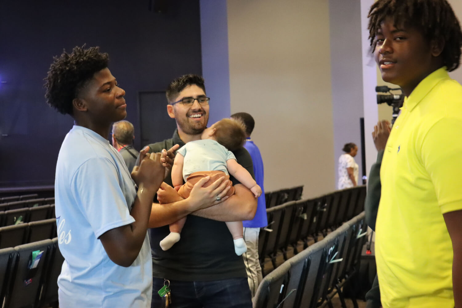 3 people with one holding baby