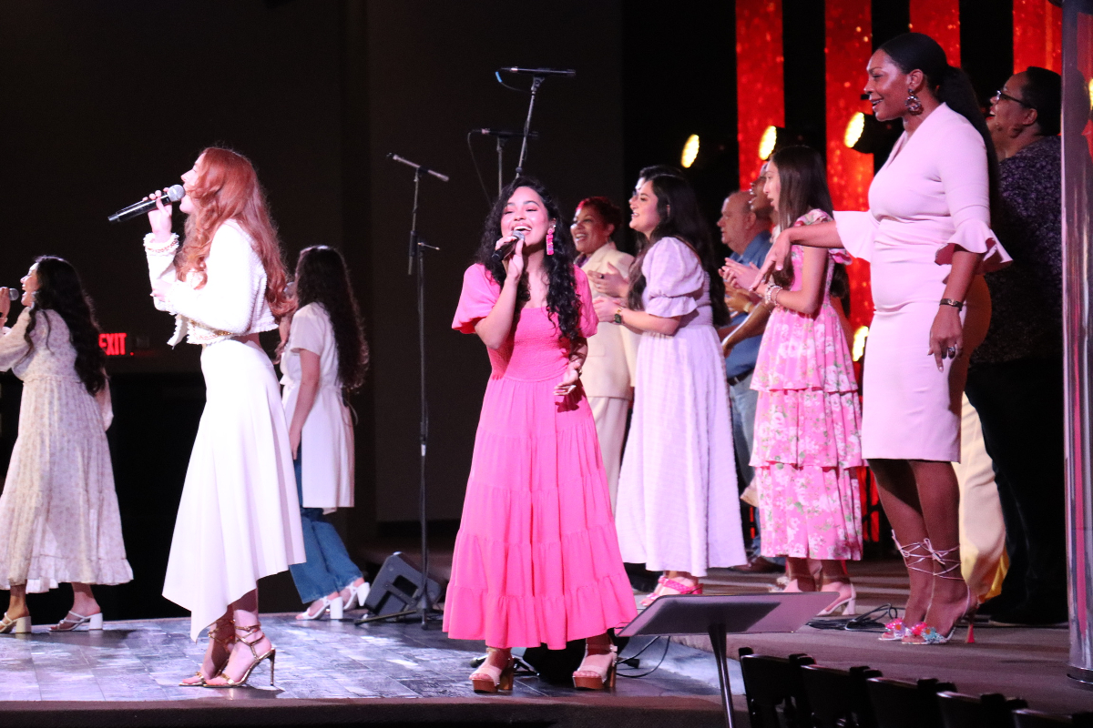 3 people singing in back of stage